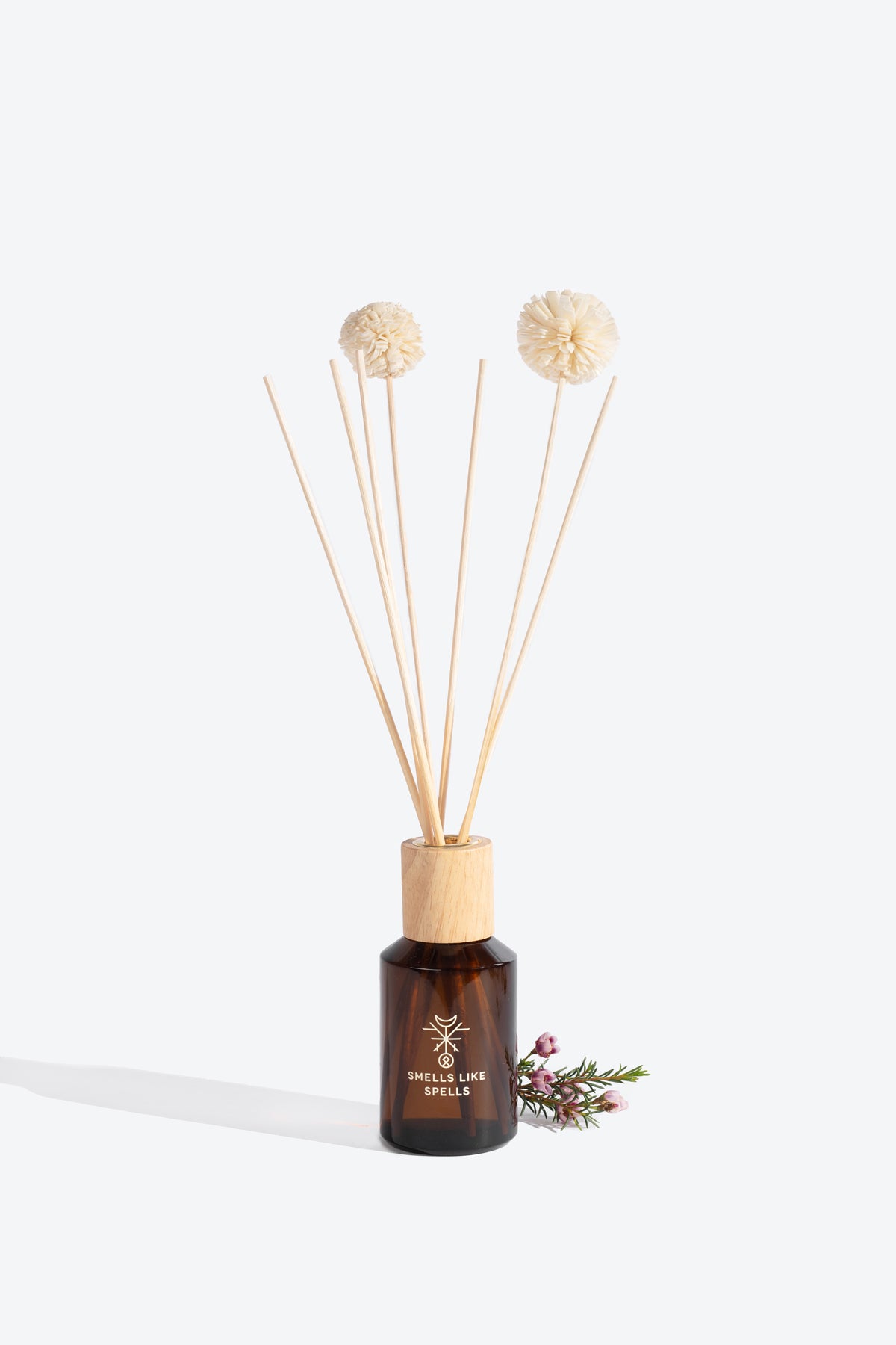 Close-up of ODIN diffuser bottle and sola wood flower