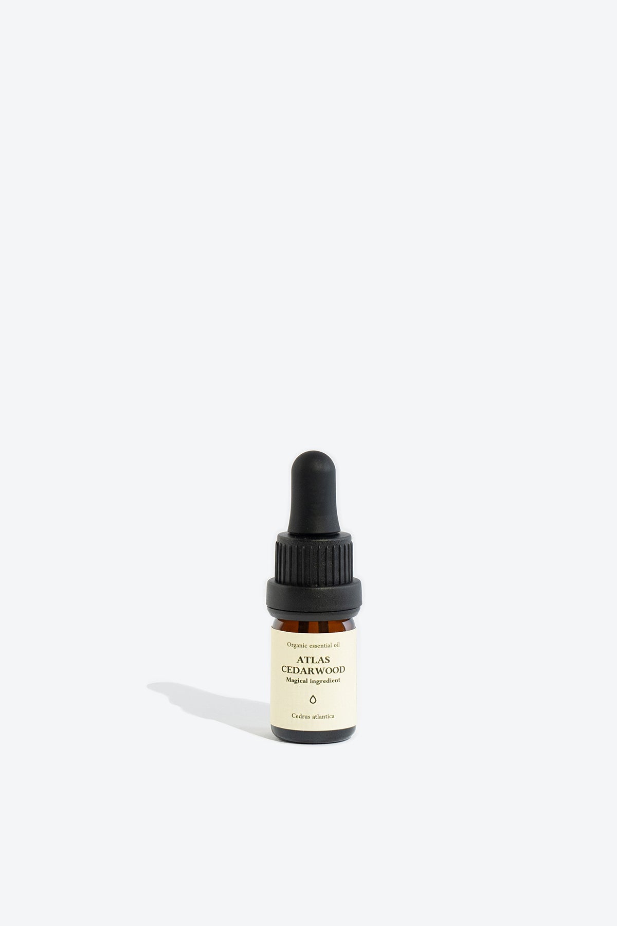 Close-up of ATLAS CEDARWOOD essential oil bottle and dropper