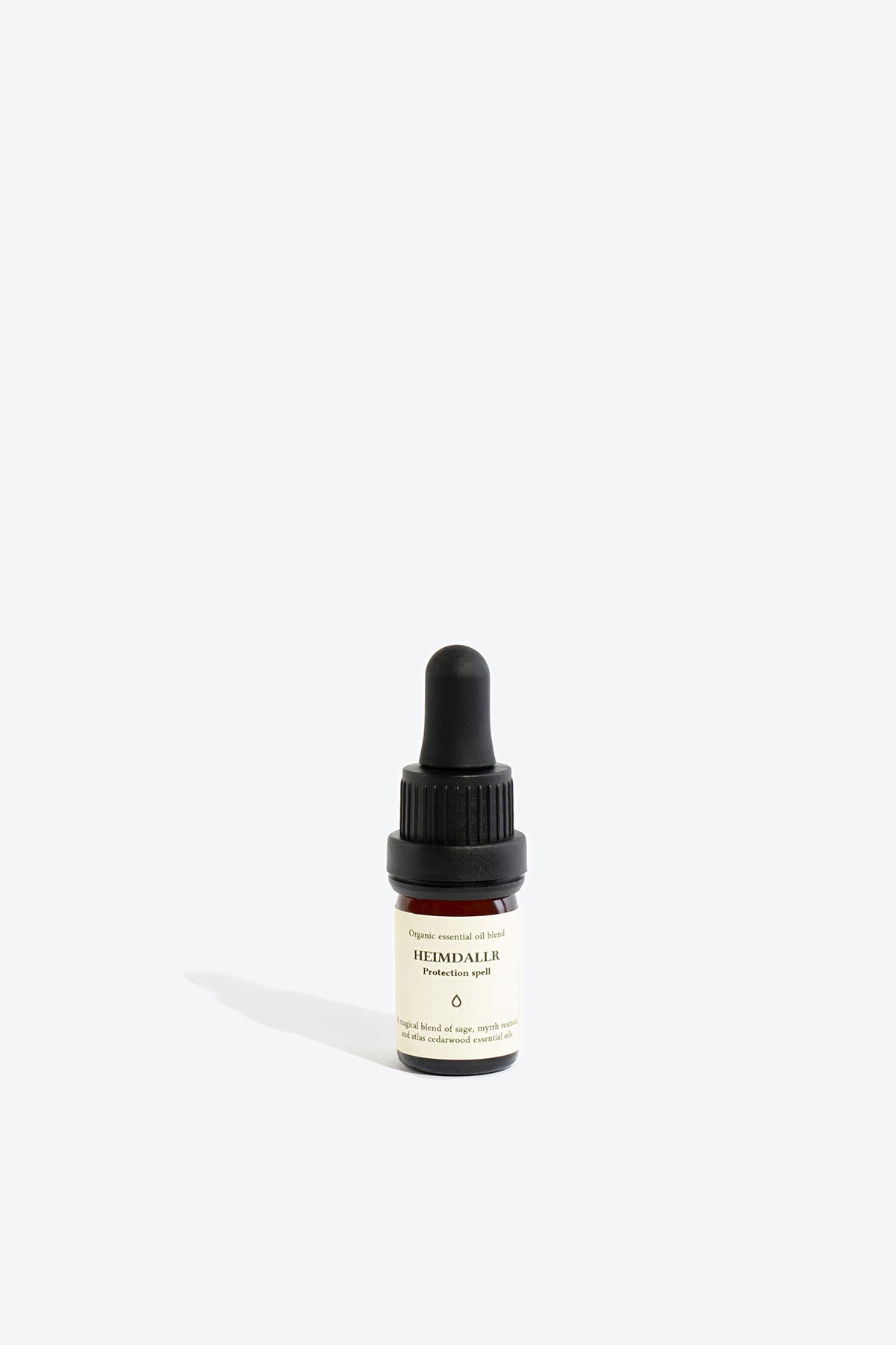 Close-up of HEIMDALLR essential oil blend bottle and glass pipette